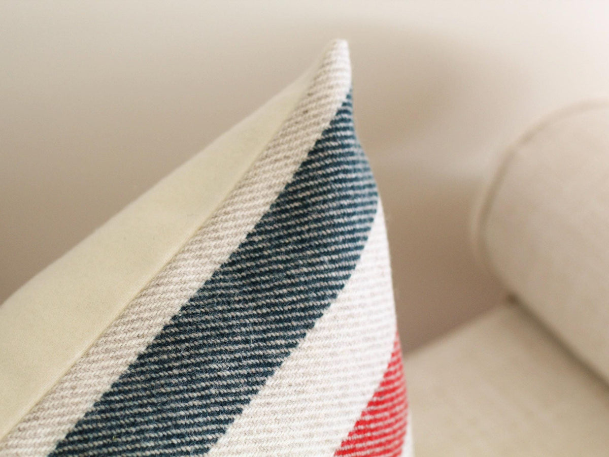 Close-up of a decorative pillow with a cream-colored fabric and a striped pattern.