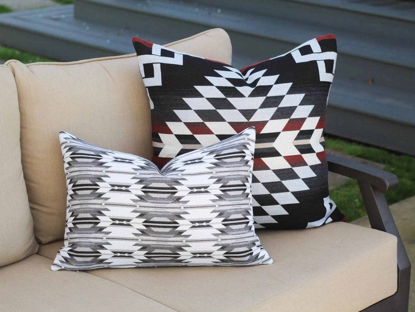 Two outdoor pillows in the black, gray, and white southwestern Wyeth Trail Stone pattern and black, red, and white Zapotec Adobe pattern.
