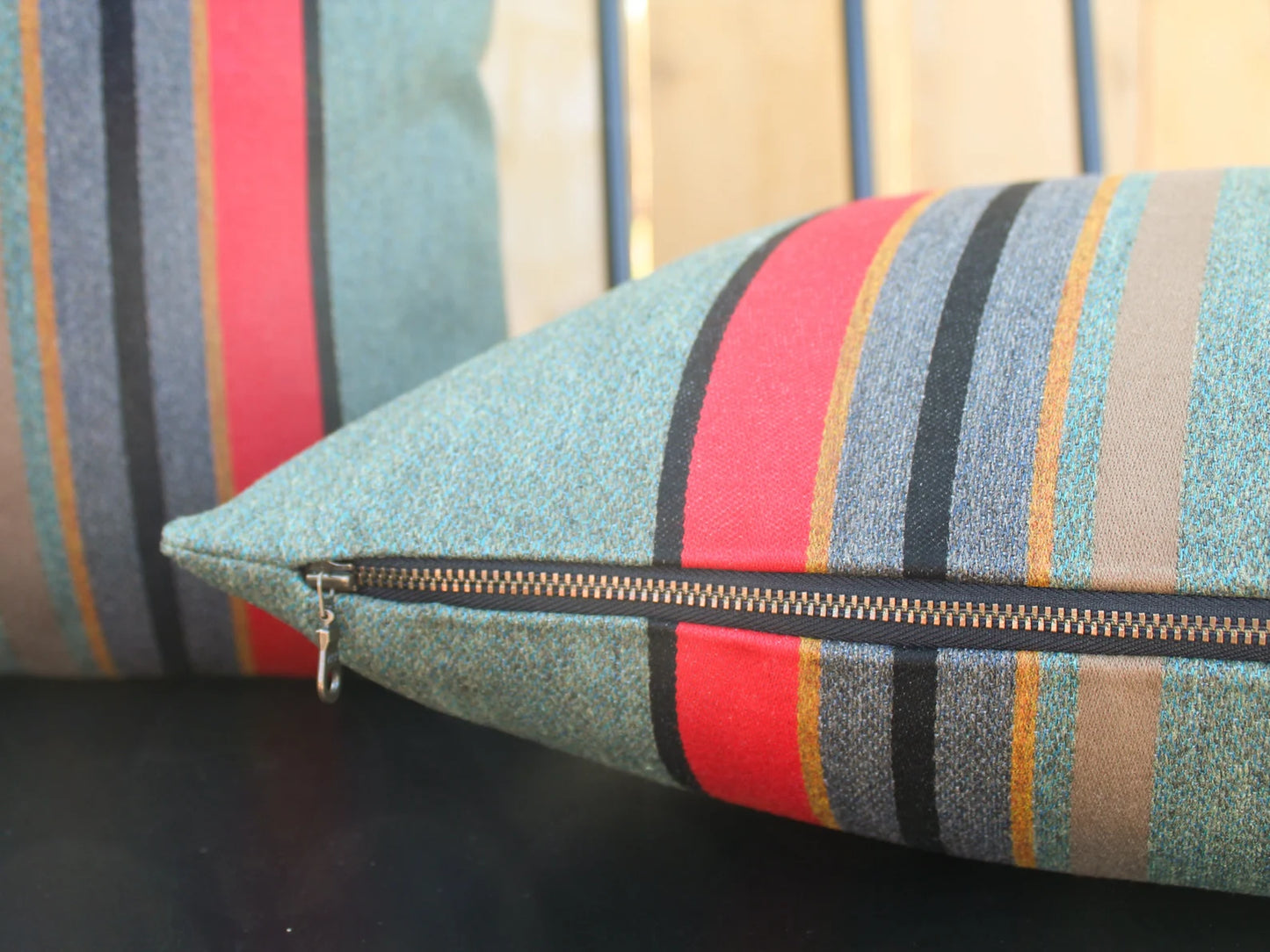 Yakima Park Heather striped pillow with a zipper on a dark surface