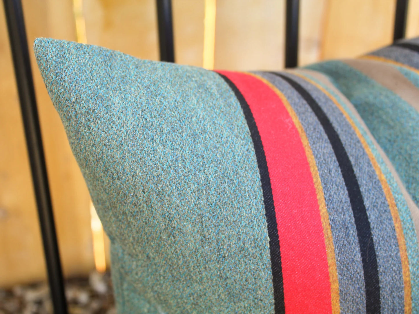 Yakima Park Heather outdoor pillow with colorful stripes on a blurred background