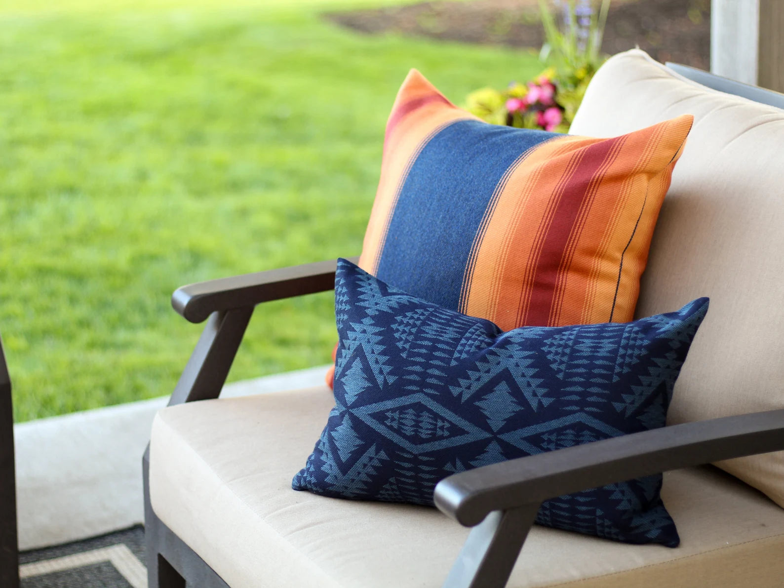 Outdoor chair with colorful pillows and a blurred green landscape in the background