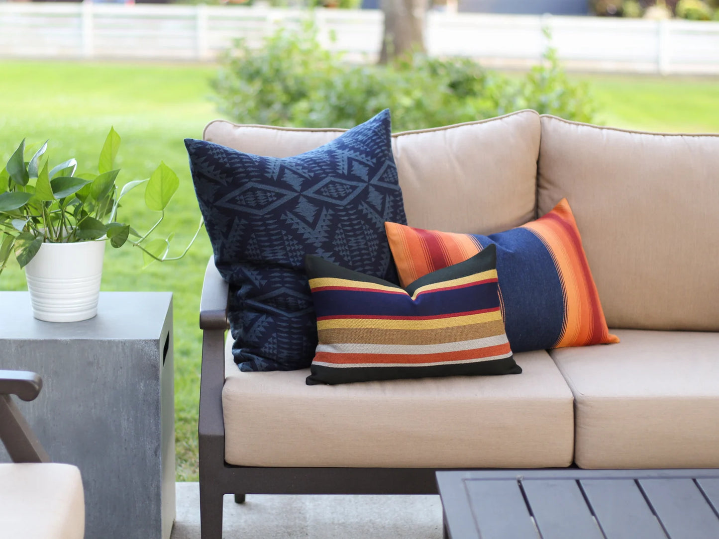 Beige outdoor sofa with colorful pillows on a patio