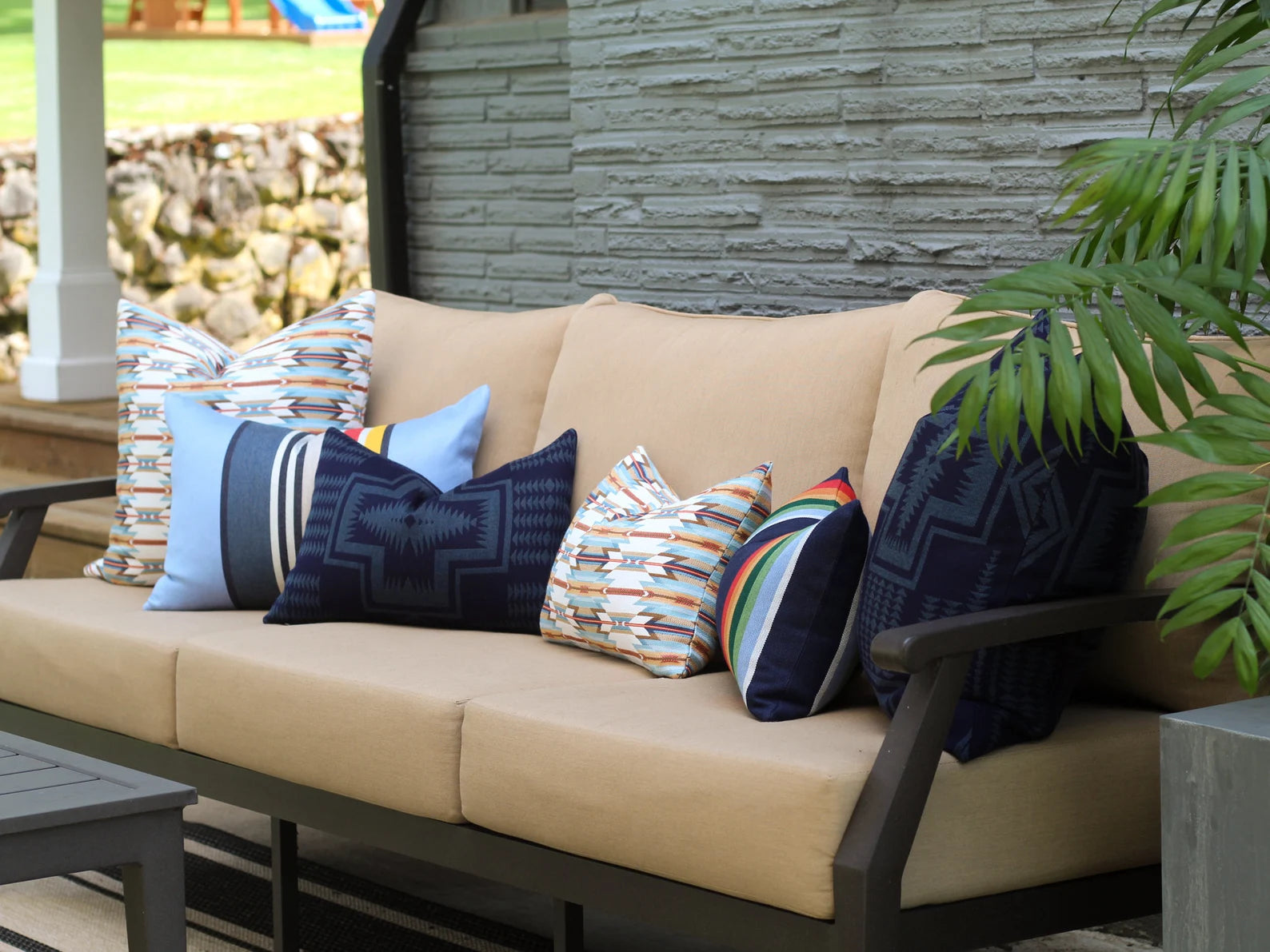Beige outdoor sofa with colorful outdoor pillows on a patio