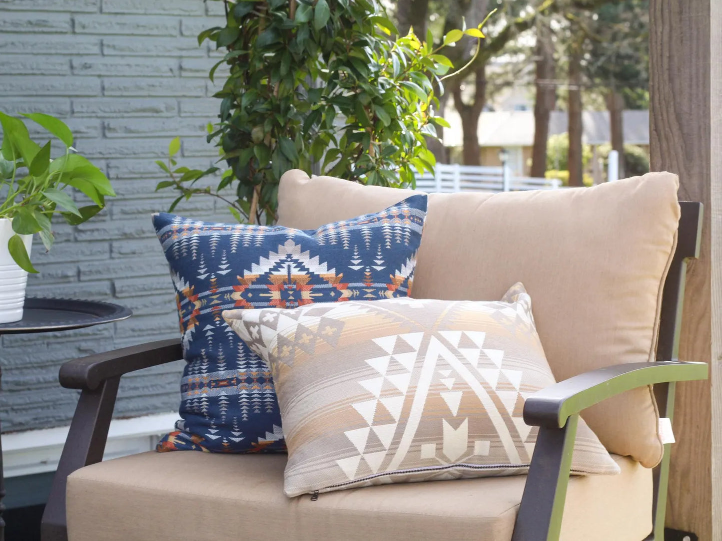 Beige outdoor chair with patterned outdoor pillows on a patio setting