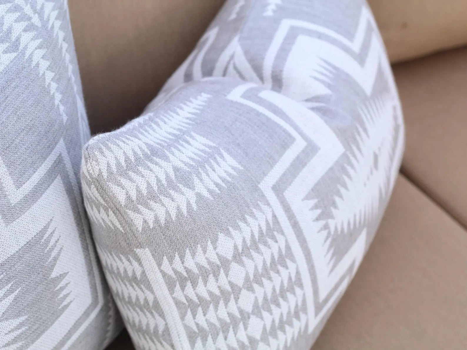 Harding Dove outdoor pillows on a beige sofa
