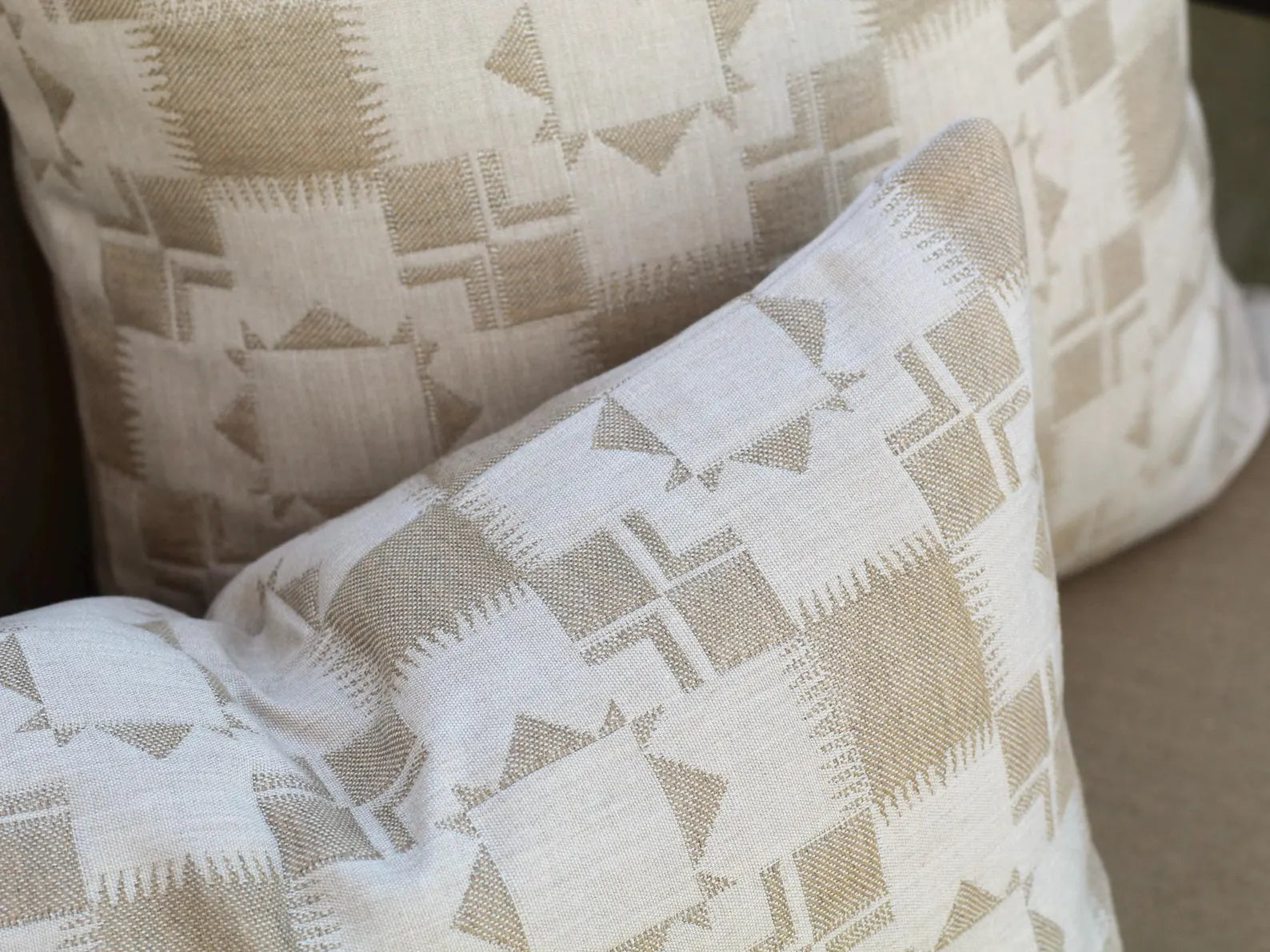 Close up of two outdoor pillow covers in the two-tone tan Silver Lake Dune pattern. This pattern has a Textural matelasse design.
