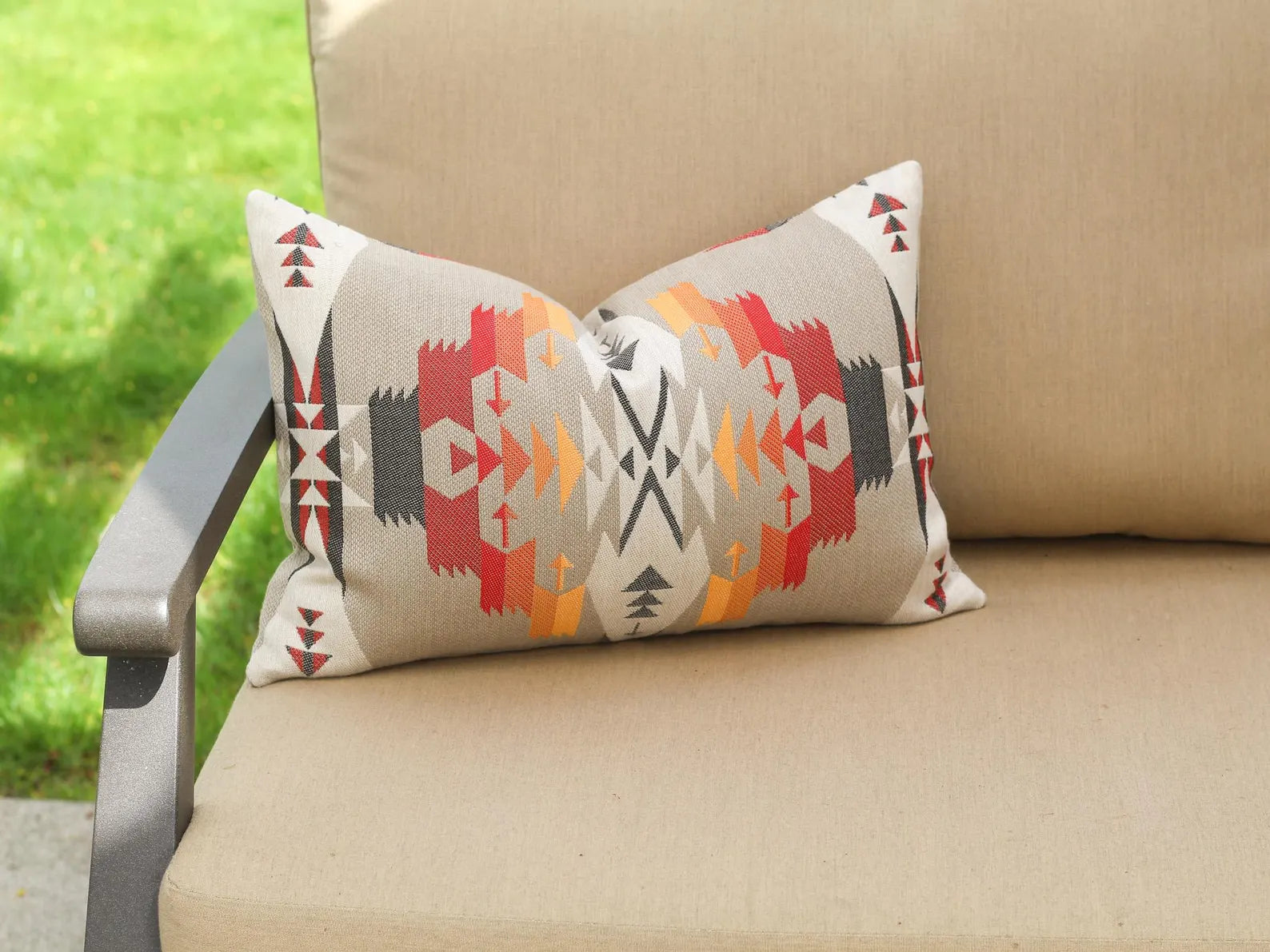 Decorative pillow in the Tucson Hawk pattern on a beige outdoor sofa