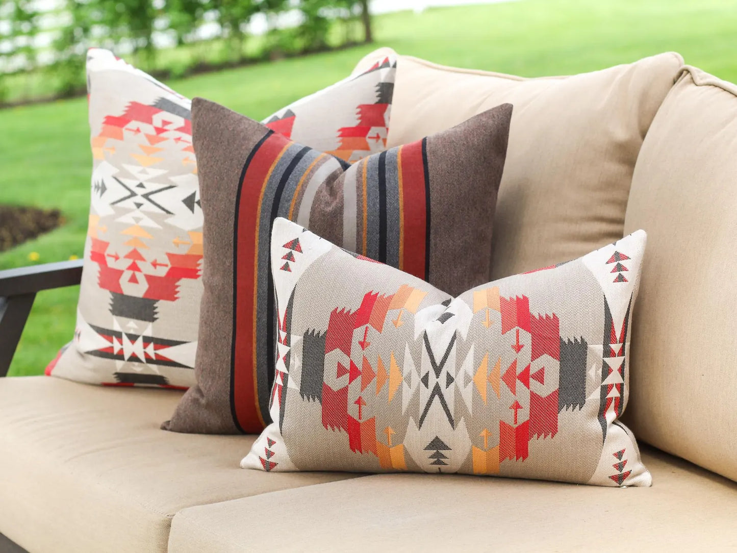 Decorative outdoor pillows on a beige outdoor sofa.