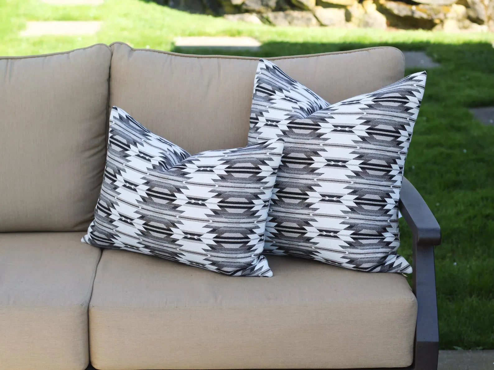 Beige outdoor sofa with outdoor pillows in the black, gray, and white southwestern Wyeth Trail Stone pattern.