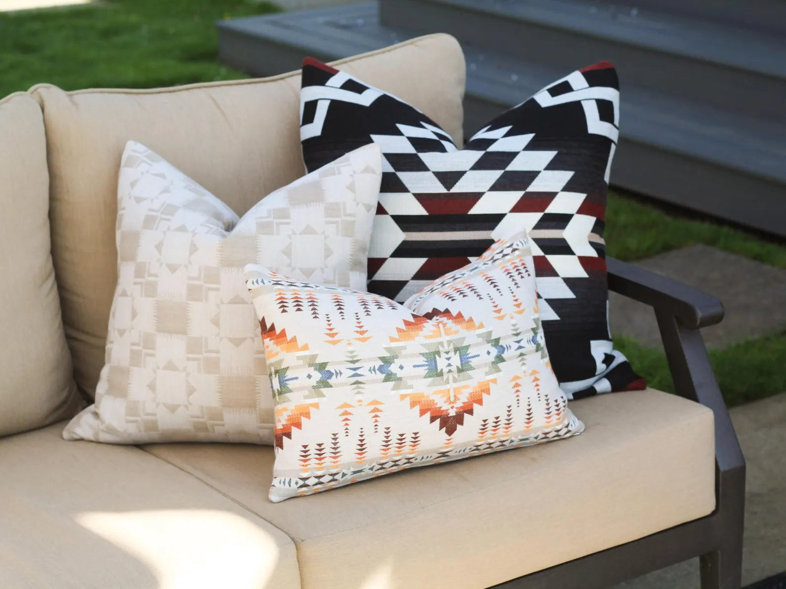 Outdoor pillows on a beige outdoor sofa with a garden background