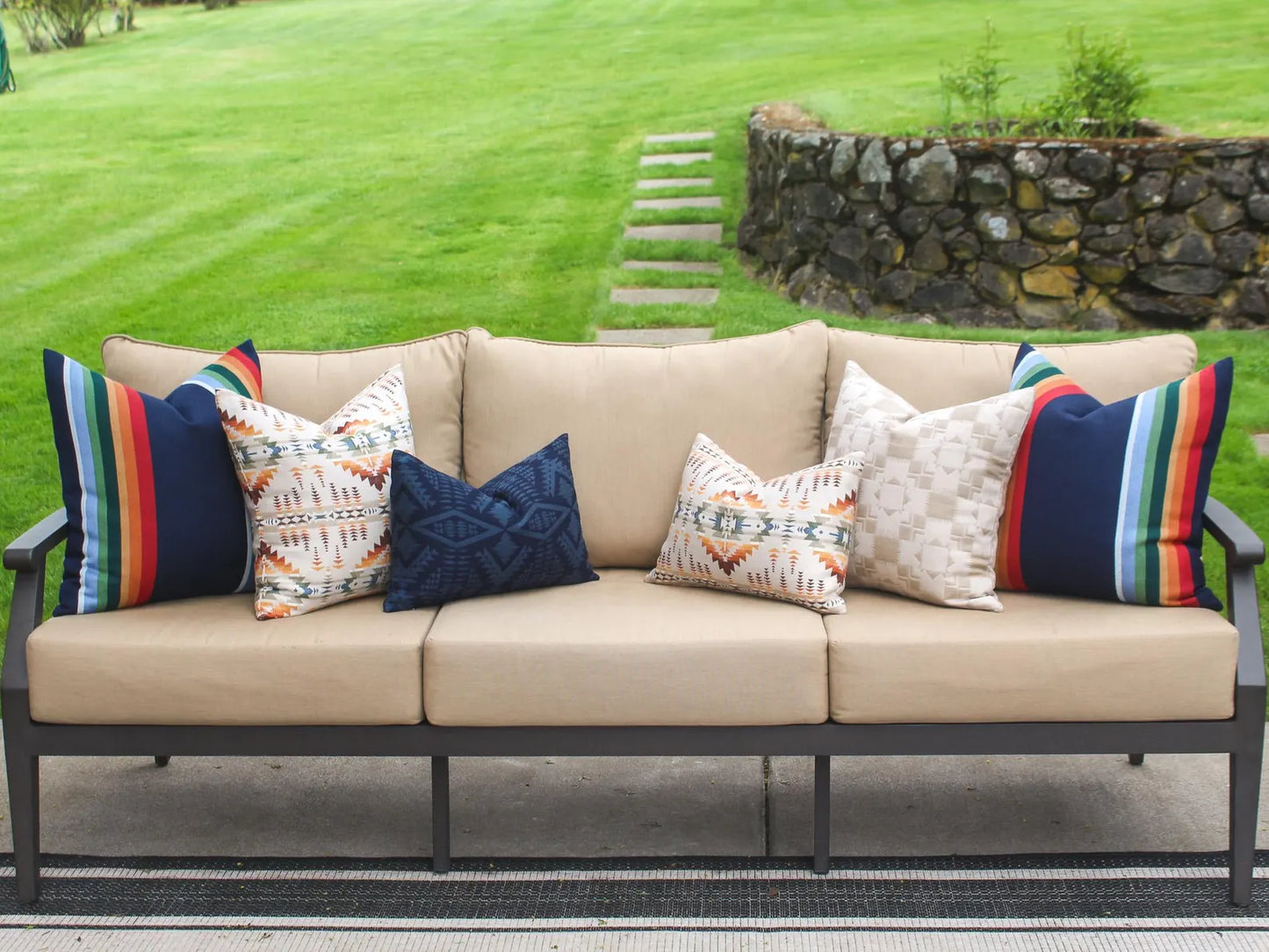 Beige outdoor sofa with colorful pillows on a patio